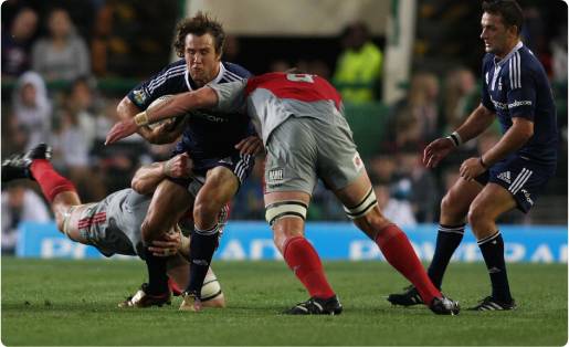 Peter Grant being tackled by two players
