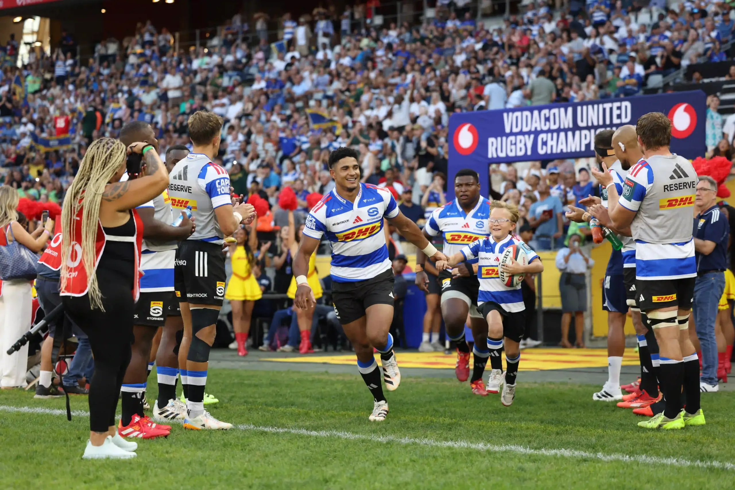 Kid Mascot runs out with Sacha Feinberg-Mngomezulu