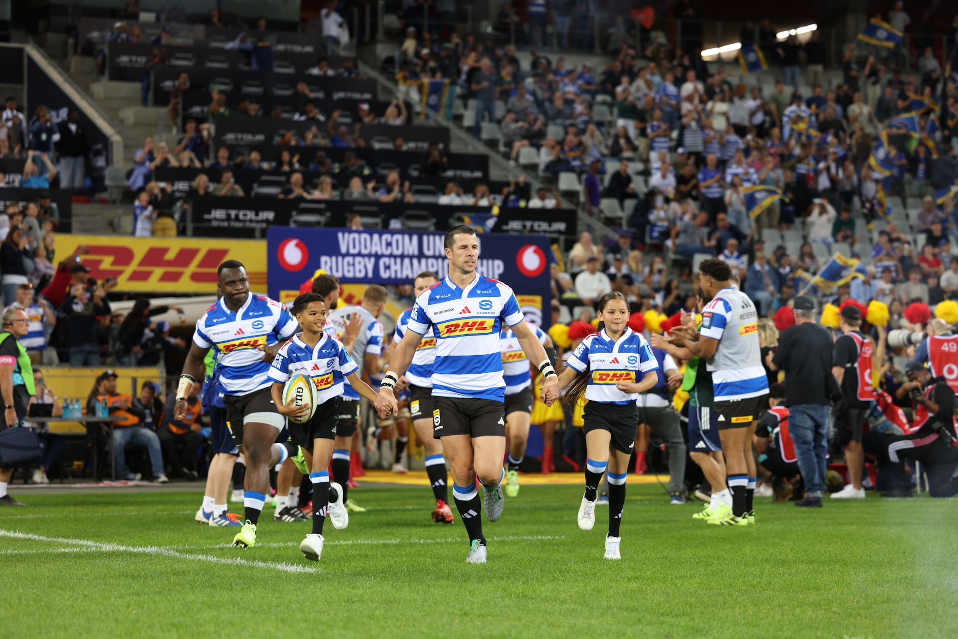 Kid mascots run out with Ruhan Nel